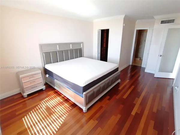 a room with a bed and wooden floor