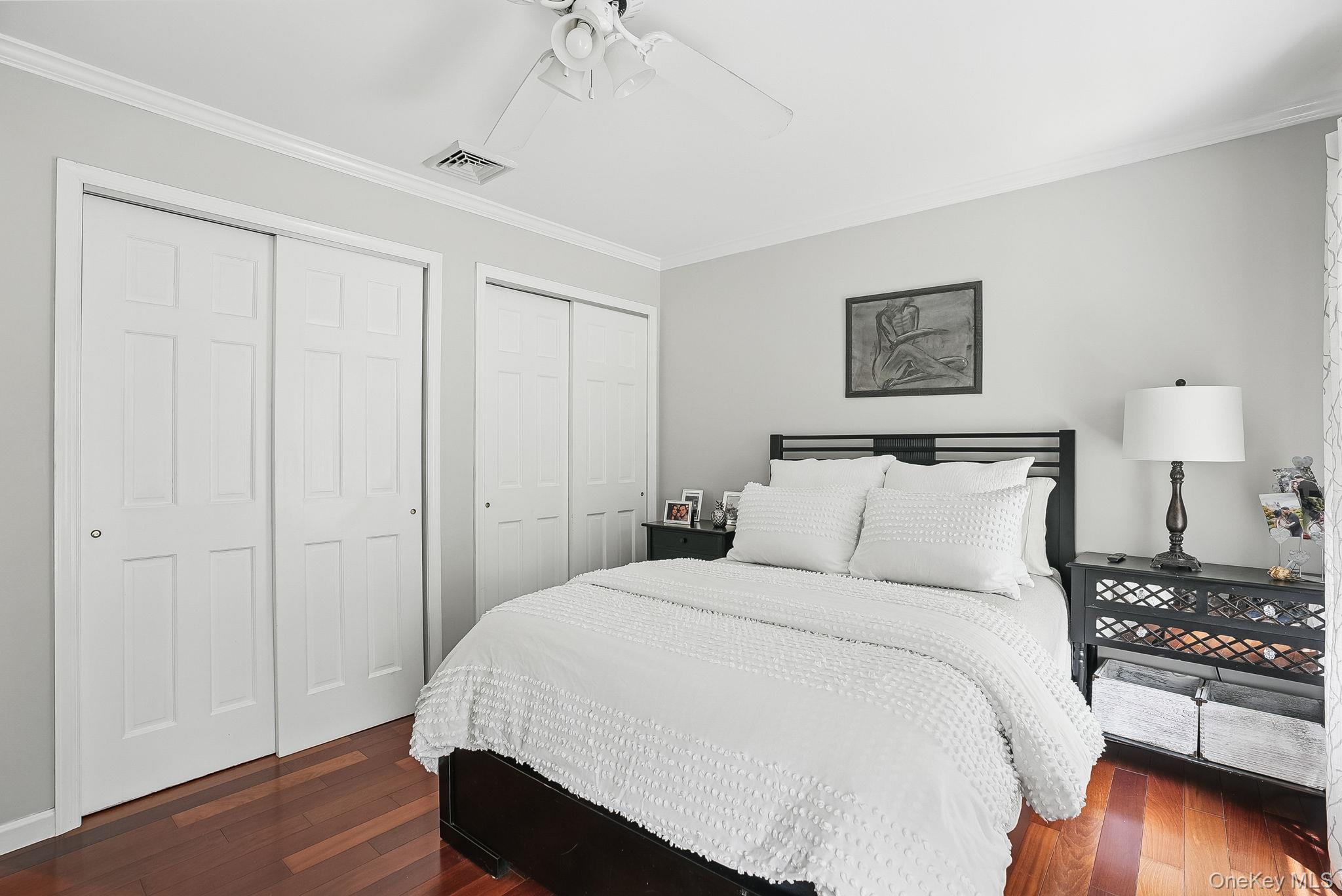 304 Church Road Putnam Valley, NY 10579 - Photo 26 of 50 Bedroom with multiple closets, dark wood-style floors, crown molding, and ceiling fan