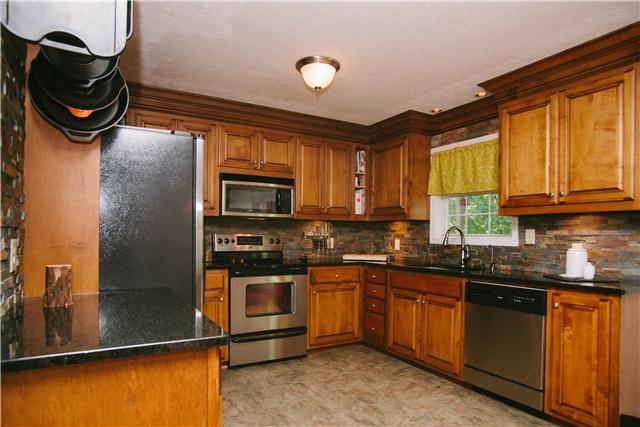 169 West Hester Road Cottontown, TN 37048 - Photo 4 of 16 Gorgeous kitchen with cherry cabinetry, slate tile back splash, and granite counters!