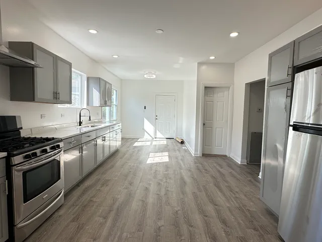 a kitchen with stainless steel appliances a stove a sink a refrigerator and cabinets