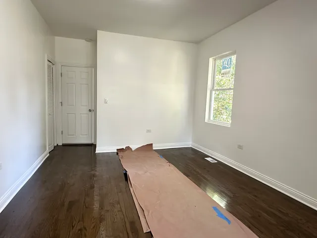 a view of a room with wooden floor and a window