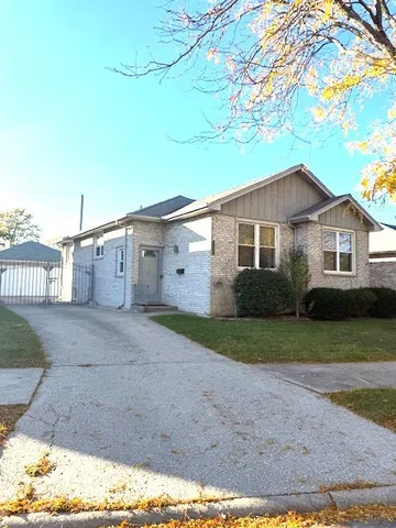 a view of a yard in front of a house with a large tree