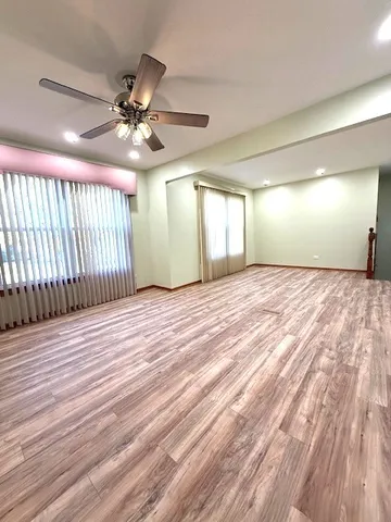 a view of a livingroom with a ceiling fan and wooden floor