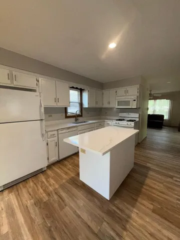 a large kitchen with cabinets and wooden floor