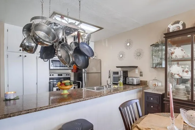 a kitchen with stainless steel appliances granite countertop a sink a stove top oven a counter space and cabinets