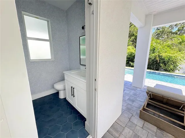 a large kitchen with kitchen island a stove a sink a center island and windows