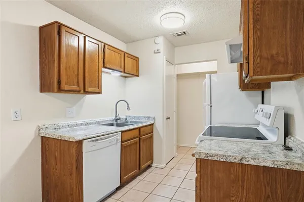 a kitchen with a granite countertop sink and cabinets
