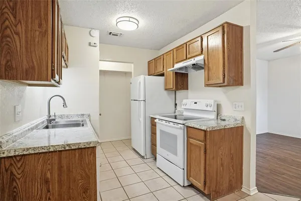 a kitchen with granite countertop a sink stove and refrigerator