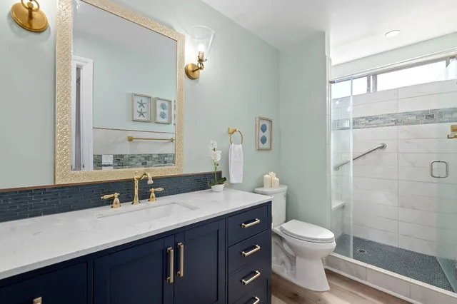 a bathroom with a granite countertop sink toilet and shower