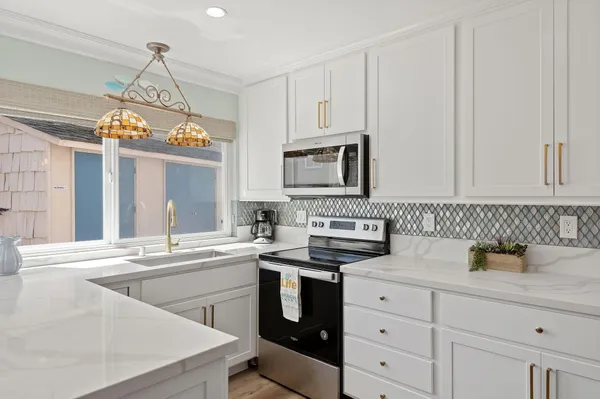 a kitchen with cabinets appliances a sink and a window
