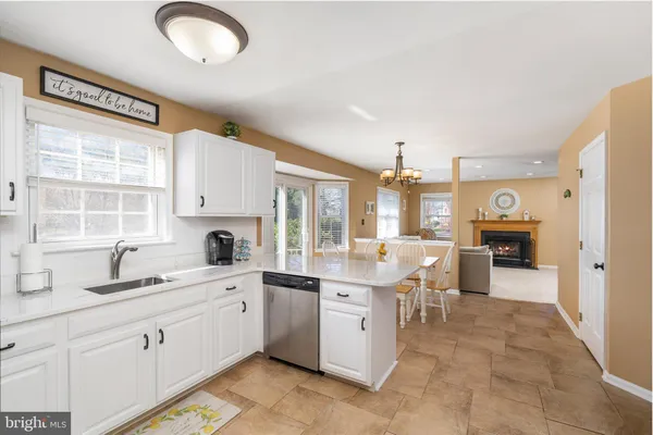 a dining room with stainless steel appliances a dining table wooden floor and a chandelier