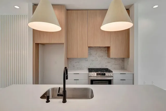 a kitchen with granite countertop a sink stainless steel appliances and cabinets