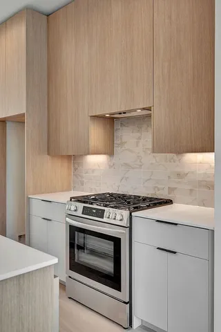 a kitchen with granite countertop cabinets stainless steel appliances and wooden floor