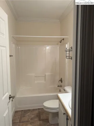 a bathroom with a granite countertop bathtub shower sink vanity and toilet