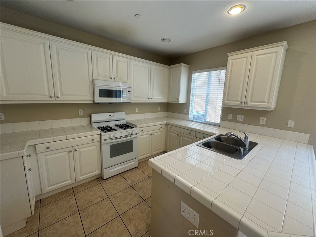9757 Edenbrook Drive Riverside, CA 92503 - Photo 11 of 40 a kitchen with a sink a stove and cabinets