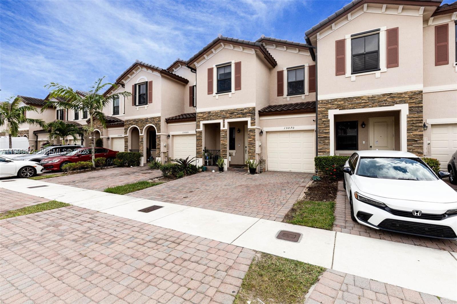 15070 Southwest 119TH Lane Miami, FL 33196 - Photo 2 of 30 a view of a white house with a yard and car parked