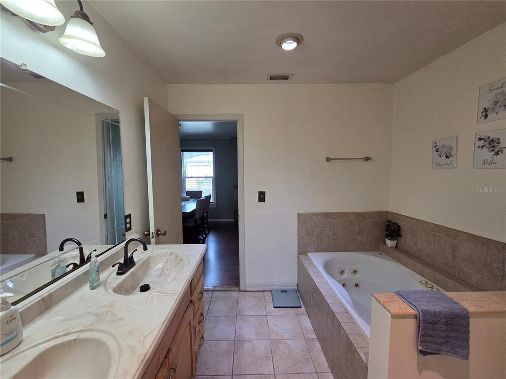 124 East F Street Frostproof, FL 33843 - Photo 28 of 37 a bathroom with a tub sink and mirror
