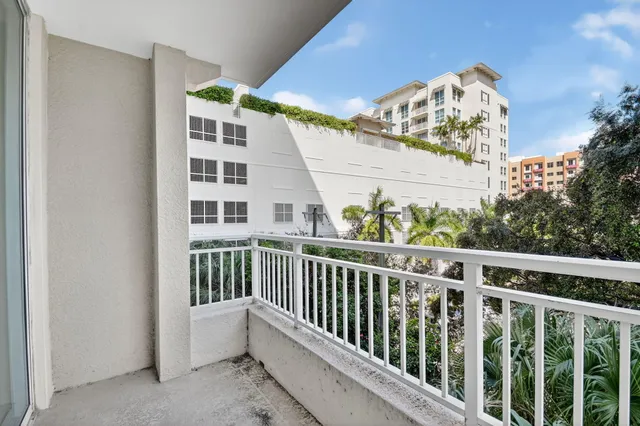 a view of a large building with a tree and plants