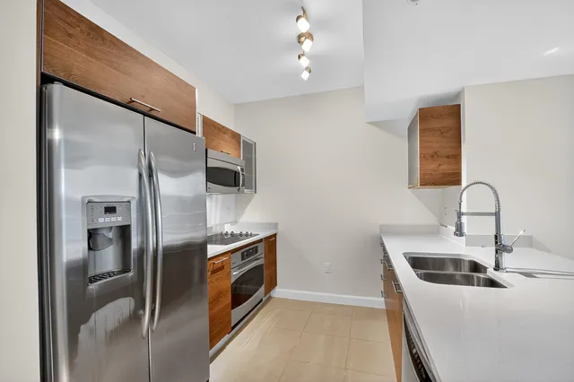 a kitchen with stainless steel appliances a refrigerator sink and stove