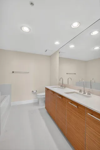 a bathroom with a granite countertop sink a toilet and shower