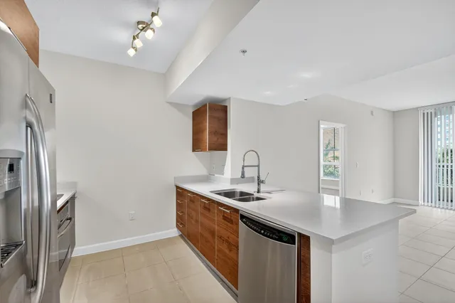 a kitchen with stainless steel appliances granite countertop a sink a refrigerator and a stove