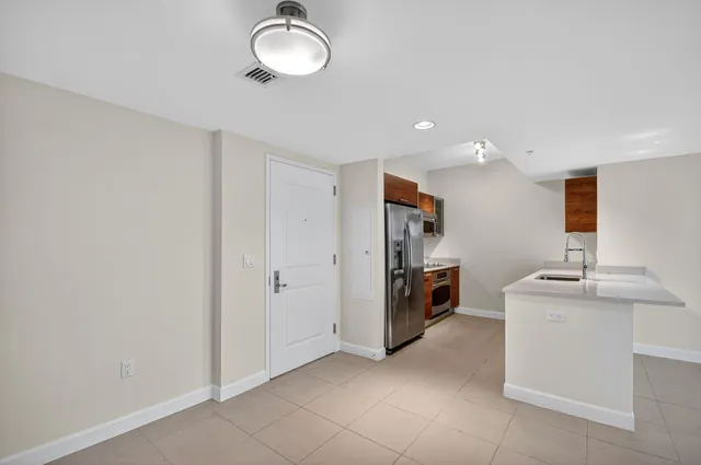 a view of a kitchen with fridge and a sink