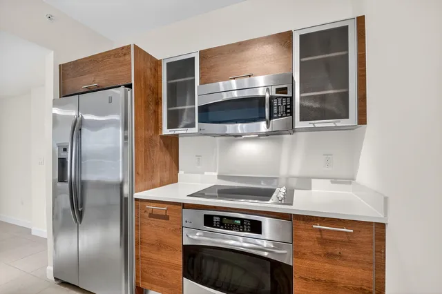 a kitchen with a refrigerator and a stove top oven