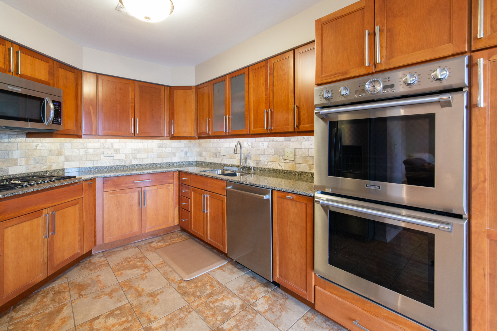 175 Boardwalk Place, Unit 301 Park Ridge, IL 60068 - Photo 6 of 20 a kitchen with stainless steel appliances granite countertop a stove microwave and sink