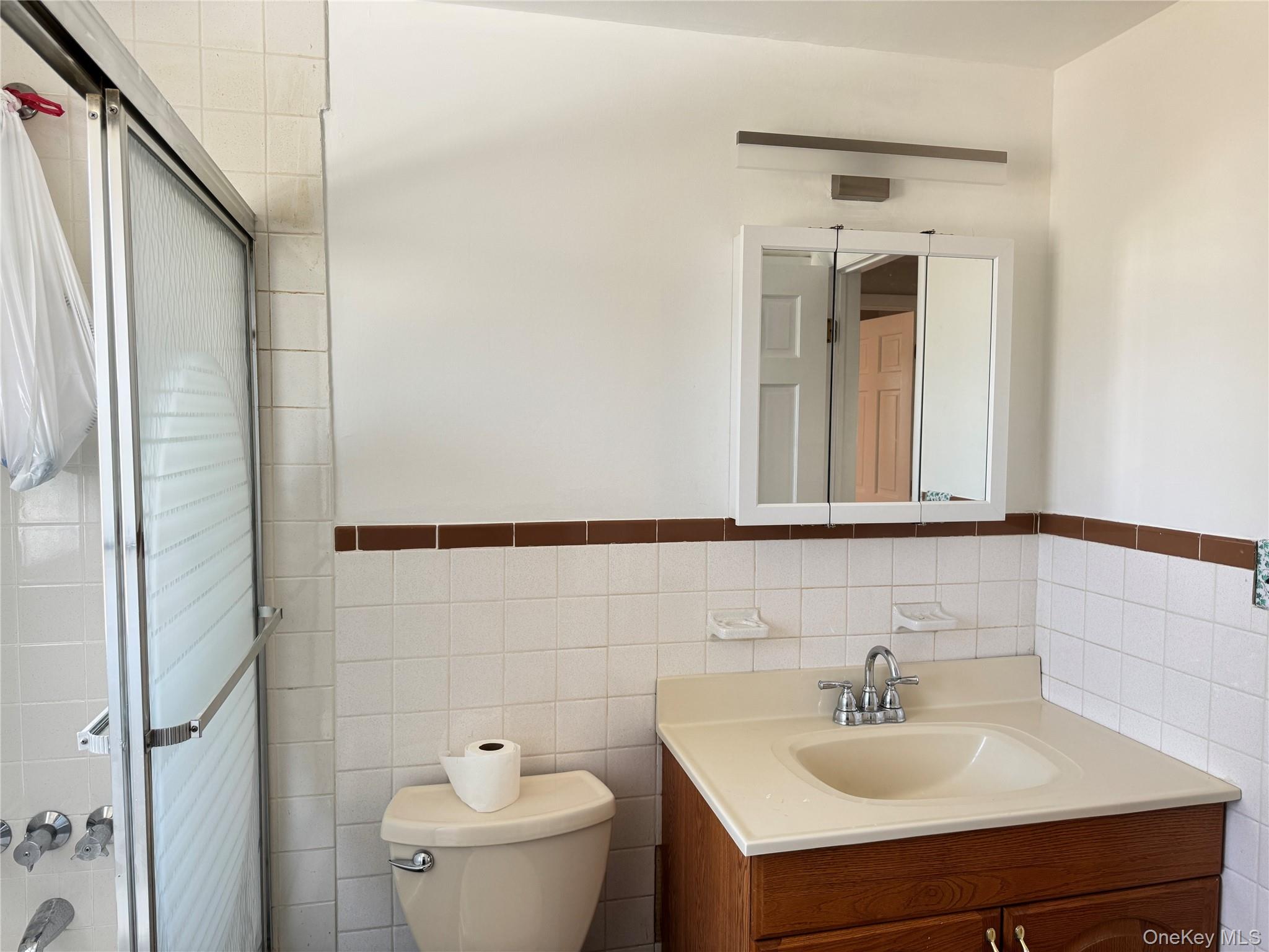 129 Spring Lane Levittown, NY 11756 - Photo 12 of 18 a bathroom with a sink a toilet and shower