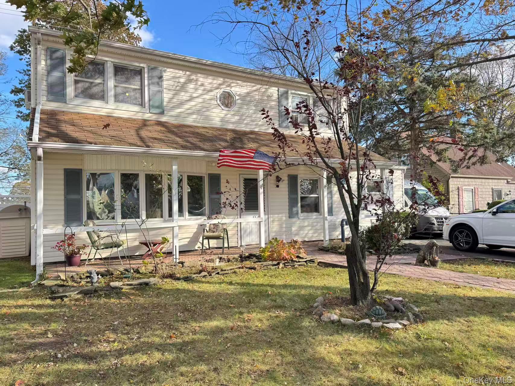129 Spring Lane Levittown, NY 11756 - Photo 2 of 18 a front view of a house with garden and sitting area