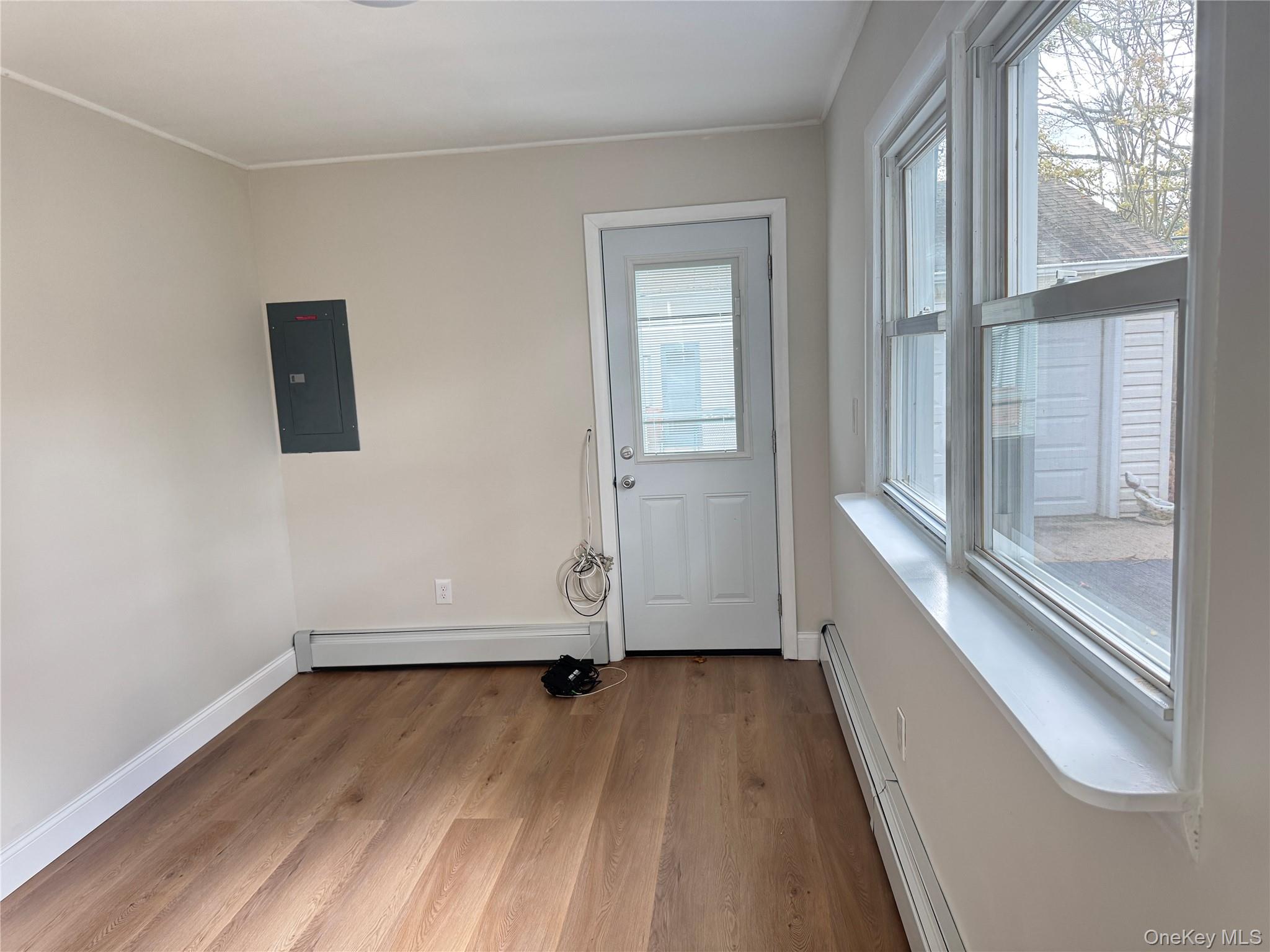 129 Spring Lane Levittown, NY 11756 - Photo 5 of 18 an empty room with wooden floor and windows