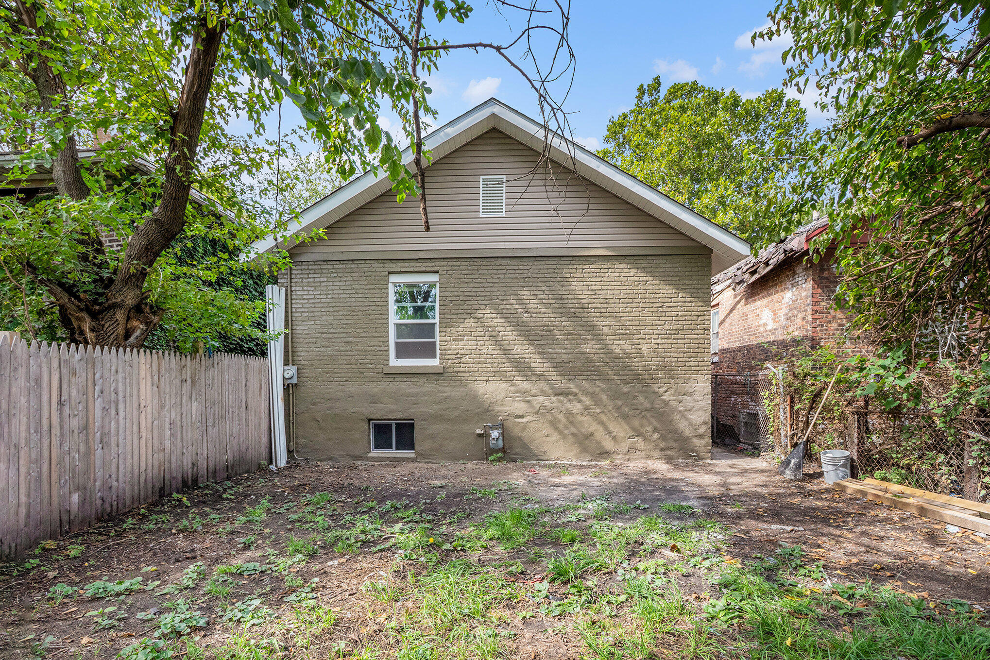 1067 Polk Street Gary, IN 46402 - Photo 13 of 13 a view of a wooden house with a yard and large tree