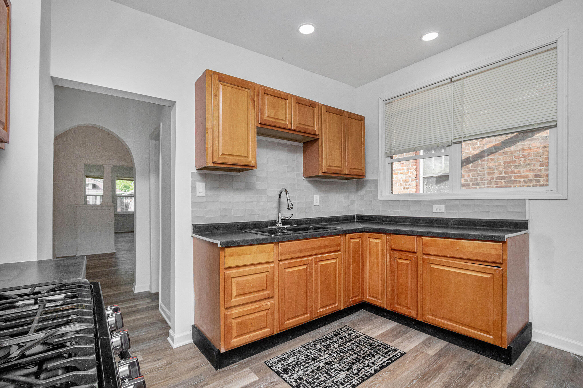 1067 Polk Street Gary, IN 46402 - Photo 4 of 13 a kitchen with stainless steel appliances a sink stove and cabinets