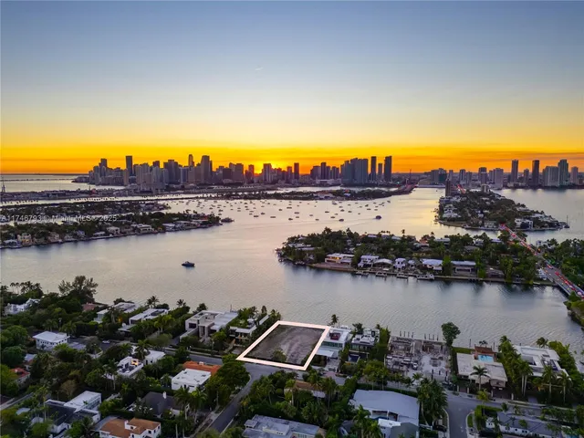 an aerial view of ocean and residential houses with outdoor space and seating
