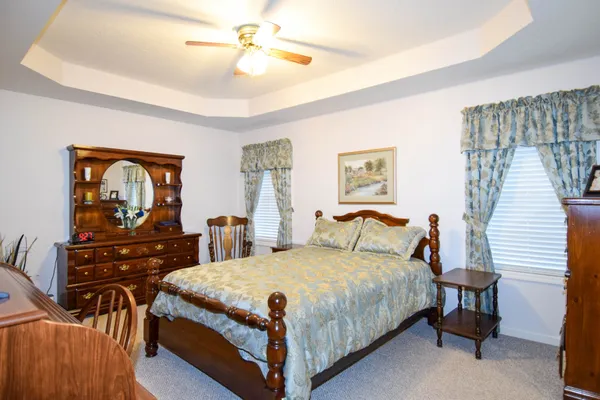 a bedroom with a bed and dresser with mirror