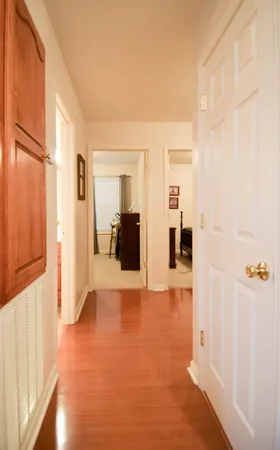 a view of a hallway with wooden floor and windows