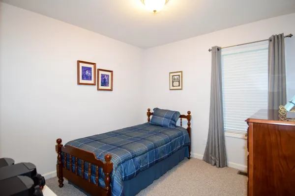 a bedroom with a bed and a painting on the wall