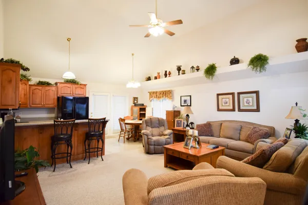 a living room with furniture kitchen view and a chandelier