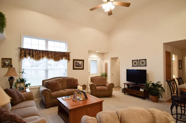 a living room with furniture a flat screen tv and a large window