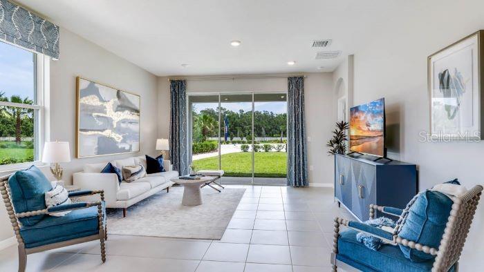 18391 Tavernside Trail Lakewood Ranch, FL 34211 - Photo 8 of 41 a living room with furniture and a flat screen tv