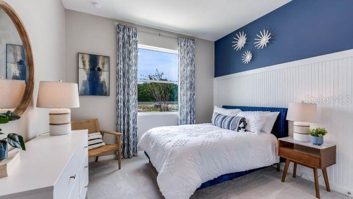 18391 Tavernside Trail Lakewood Ranch, FL 34211 - Photo 10 of 41 a bedroom with a large bed and a chandelier