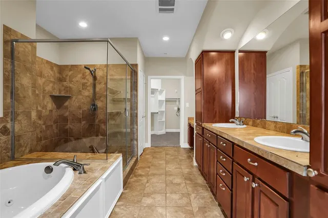 an empty room with ceiling fan and windows