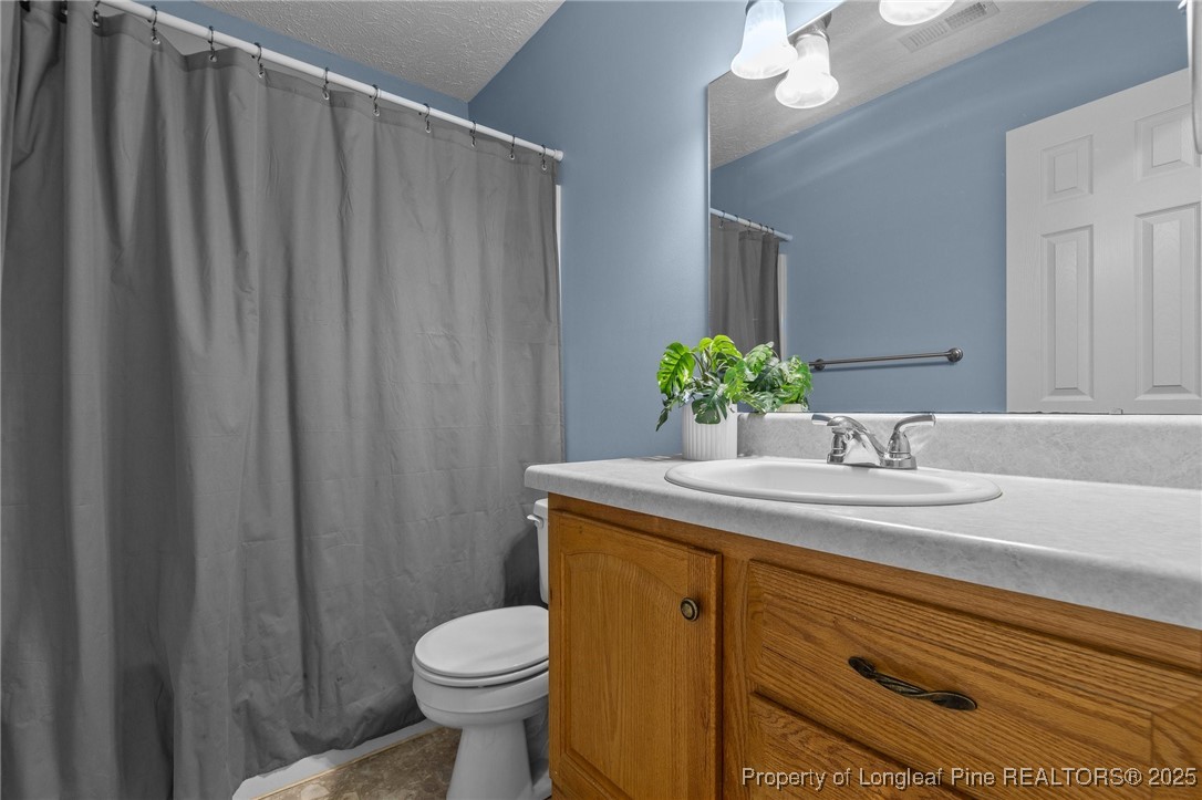 1205 Hobson Road Raeford, NC 28376 - Photo 14 of 33 a bathroom with a granite countertop sink toilet and a mirror