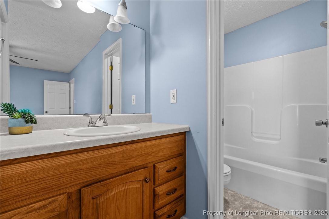 1205 Hobson Road Raeford, NC 28376 - Photo 24 of 33 a bathroom with a granite countertop sink a mirror and a bathtub