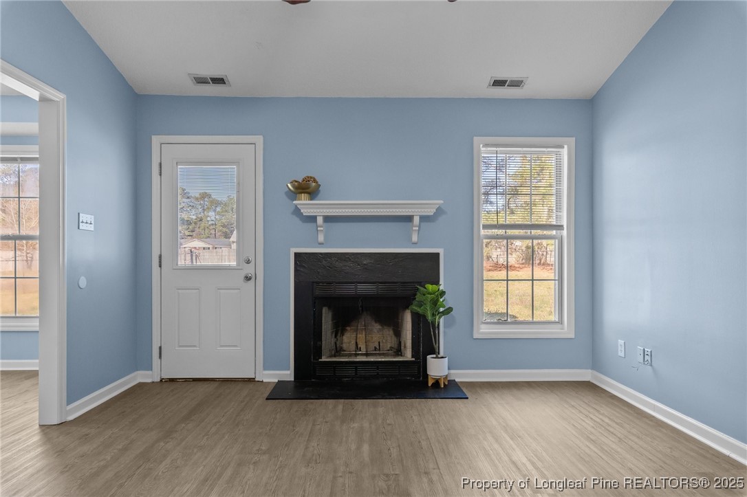 1205 Hobson Road Raeford, NC 28376 - Photo 10 of 33 an empty room with windows and fireplace