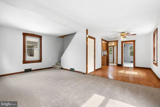 a view of an empty room with window and stairs