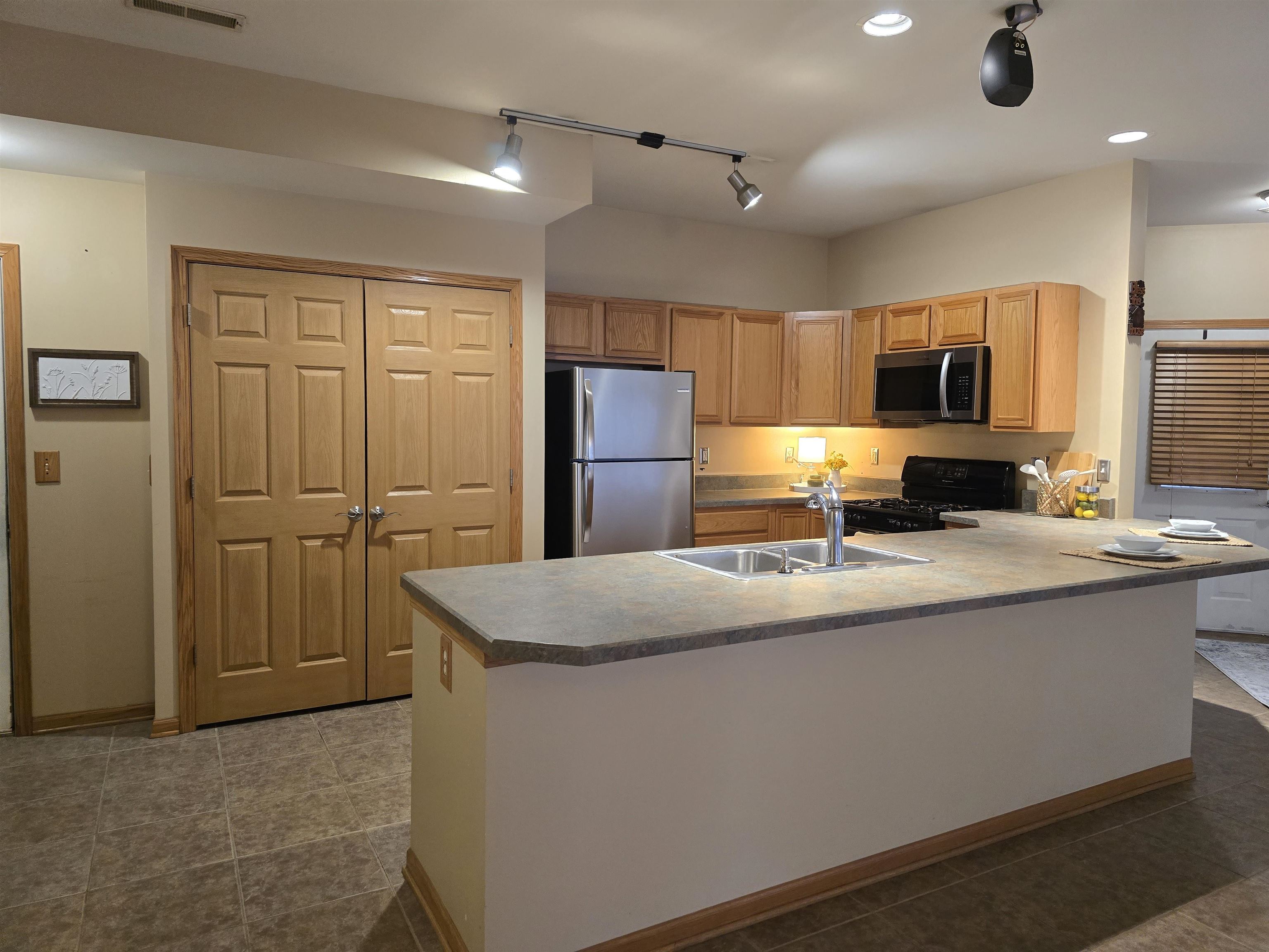 7593 Magnolia Trail Cherry Valley, IL 61016 - Photo 7 of 32 a kitchen with stainless steel appliances granite countertop a refrigerator a sink a stove a microwave and island with wooden floor