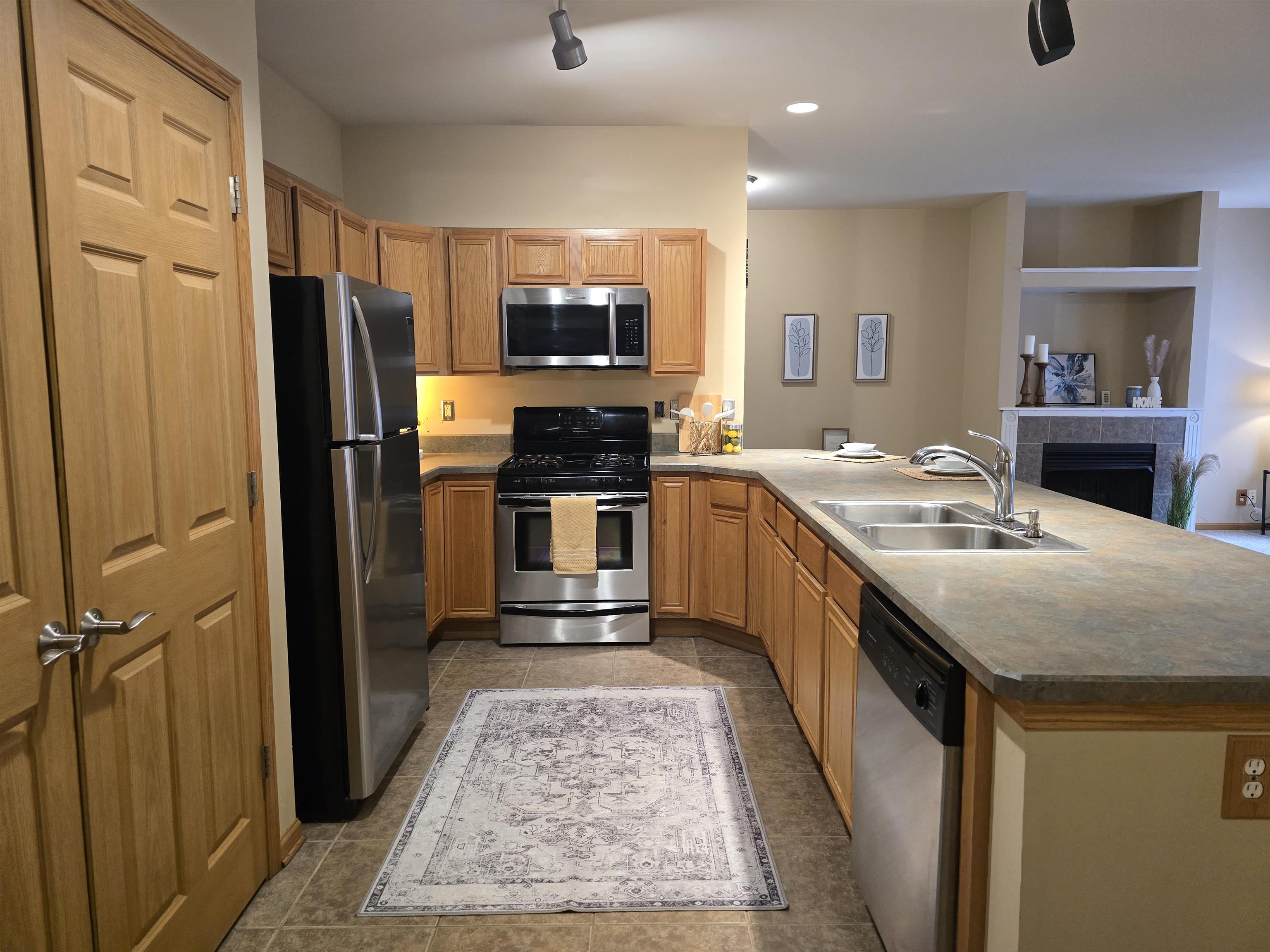 7593 Magnolia Trail Cherry Valley, IL 61016 - Photo 8 of 32 a kitchen with stainless steel appliances granite countertop a sink stove and refrigerator