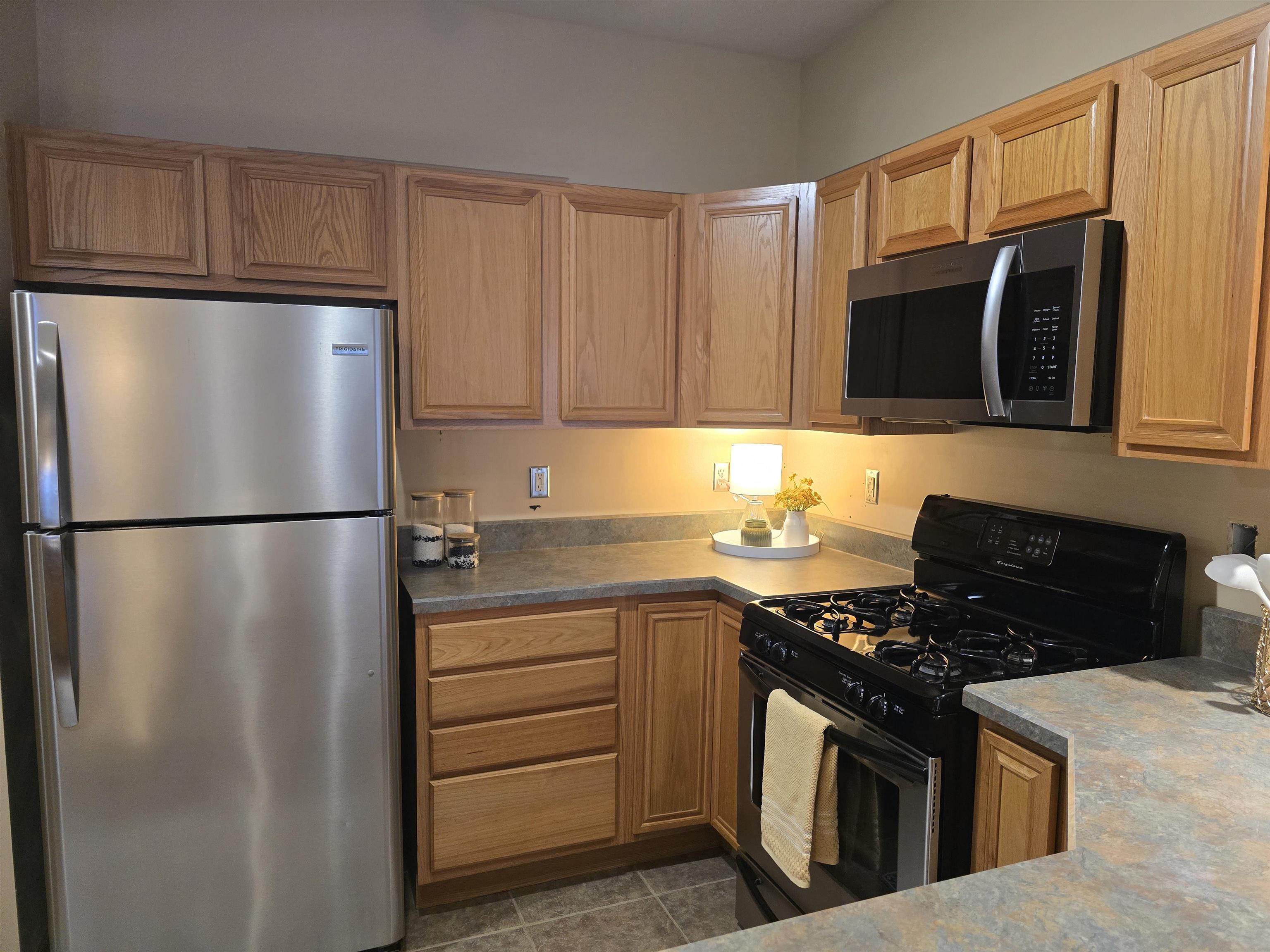 7593 Magnolia Trail Cherry Valley, IL 61016 - Photo 10 of 32 a kitchen with stainless steel appliances granite countertop a refrigerator stove top oven and sink