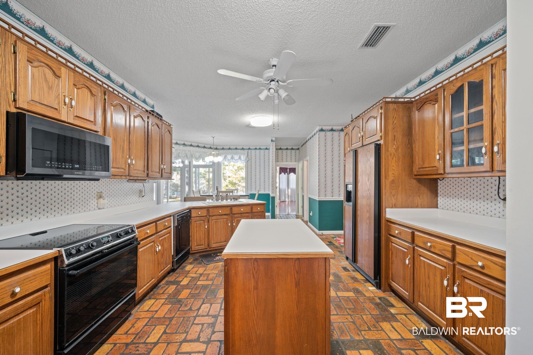 15801 Maytower Road Bay Minette, AL 36507 - Photo 20 of 43 Kitchen with ceiling fan, a kitchen island, black appliances, and a textured ceiling